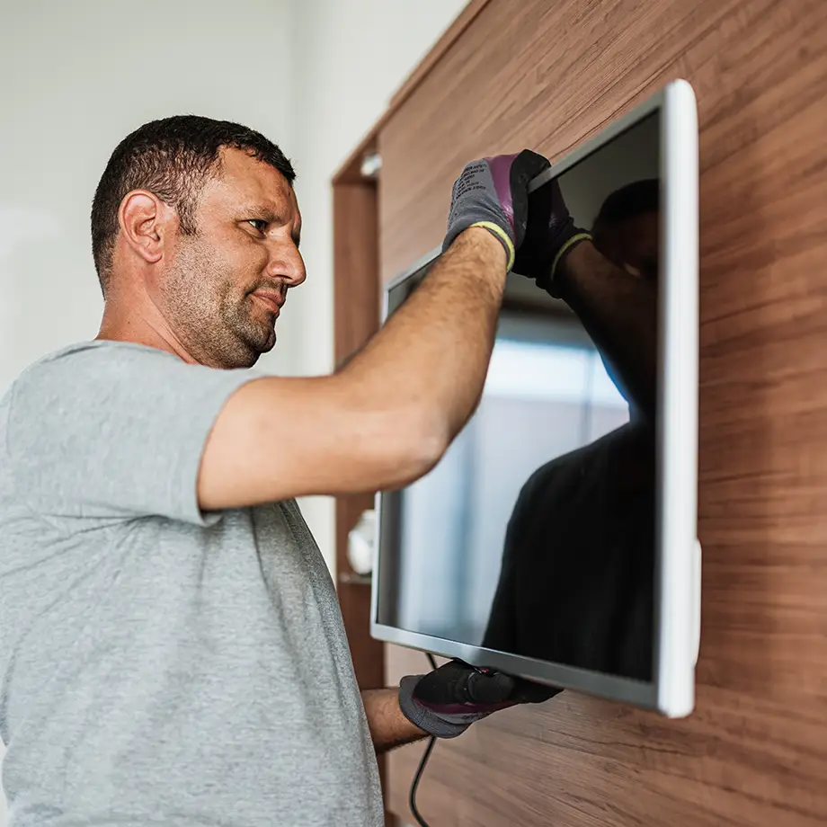 Professional AV engineer installing a screen with precision