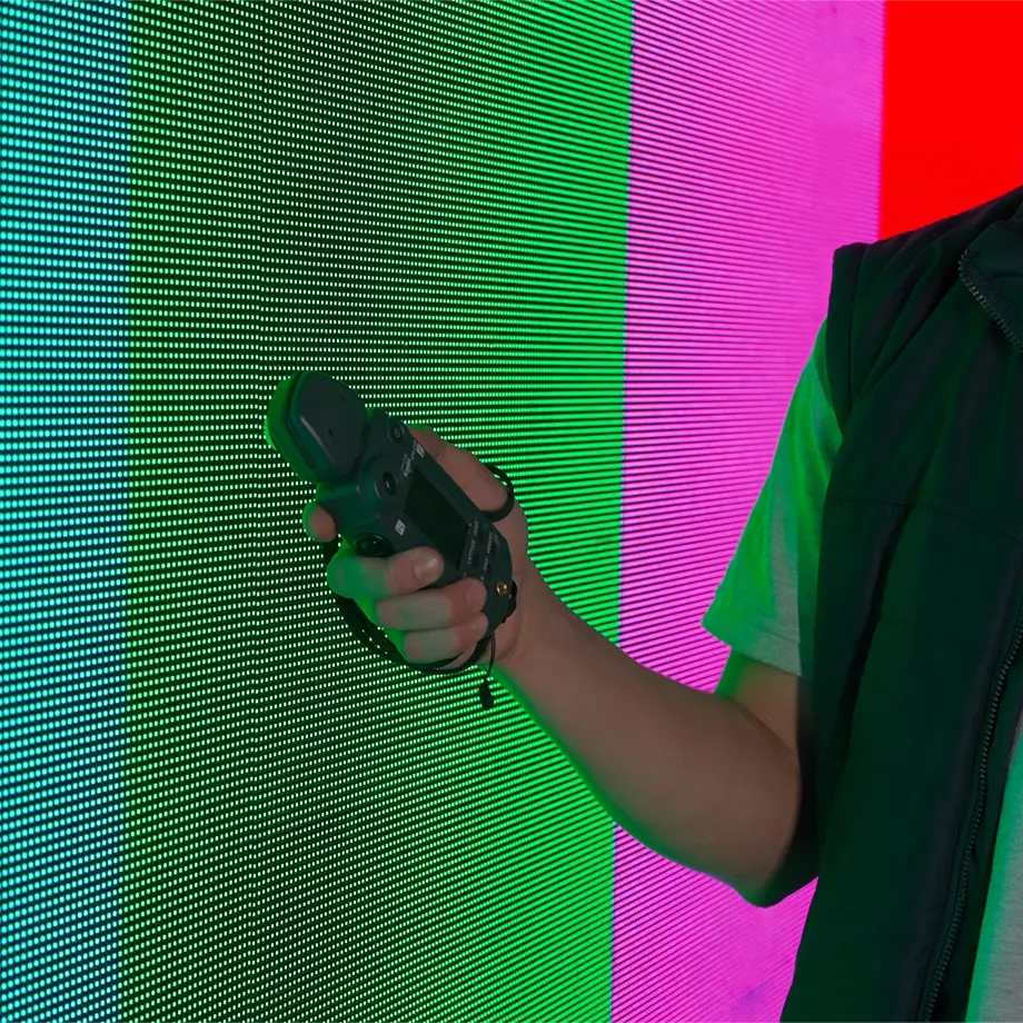 Technician testing LED display for colour calibration and performance reliability during AV maintenance