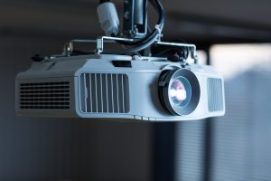 Office projector being cleaned during AV maintenance servicing